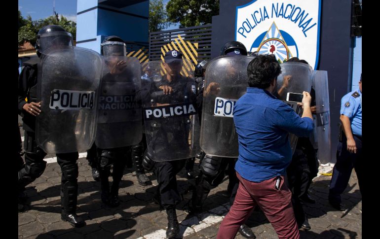 Agentes de la policía nacional repliegan al periodista Wilfedo Miranda del semanario Confidencial. EFE / J. Torre