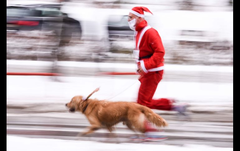 Un hombre disfrazado de Santa Claus participa con su perro en una carrera en Pristina, Kosovo, en la cual se recaudan fondos para familias necesitadas. AFP/A. Nimani