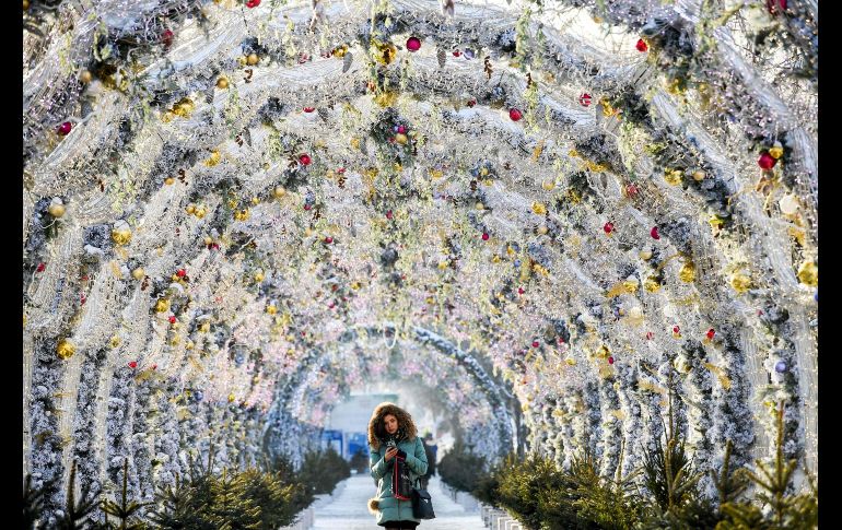 Una mujer camina por un túnel decorado con luces por la temporada decembrina en Moscú, Rusia. AFP/K. Kudryavtsev