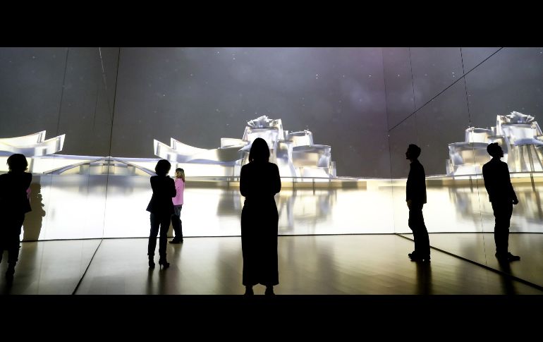Visitantes en el Museo Guggenheim en Bilbao, España,  observan un video de acercamiento sensorial sobre la historia del Museo tras la reforma de la sala Zero para conocer a fondo el edificio de Frank O. Gehry y el contenido de su colección de obras de arte. EFE/L. Tejido
