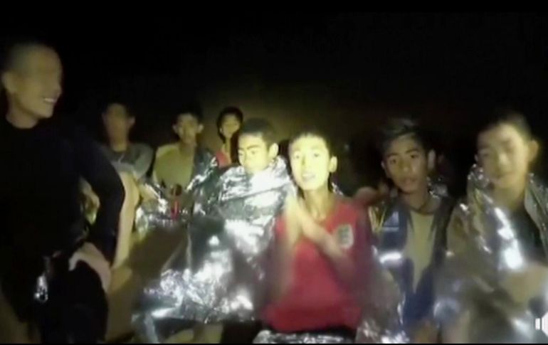 Niños del grupo de 12 integrantes de un equipo de futbol y su entrenador se ven dentro de una cueva en Mae Sai, Tailandia, junto a marinos que los acompañan mientras se hallaba la mejor forma de sacarlos. AP/Thai Navy Sea/ARCHIVO