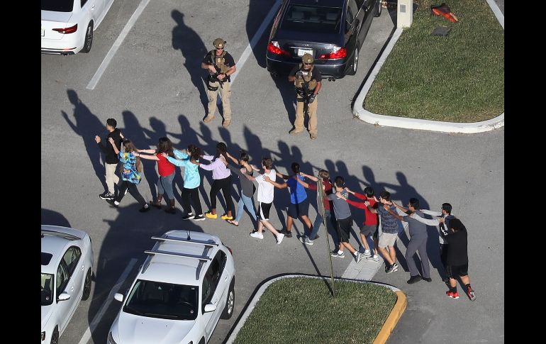 Estudiantes salen de la preparatoria Marjory Stoneman Douglas en Parkland, Florida, tras un tiroteo en el cual un joven mató a 17 personas el 14 de febrero. AFP/J. Raedle