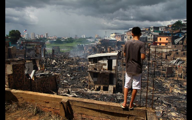 Un vecino observa los escombros del barrio Educandos en Manaos, Brasil, luego de un incendio desatado la víspera. AP/E. Barros