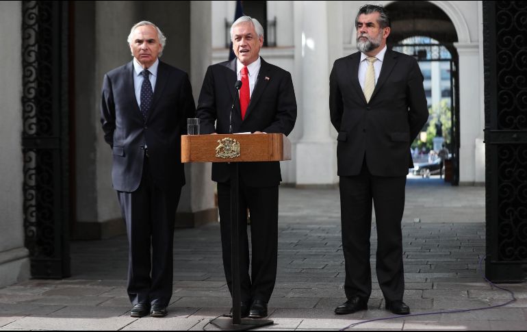 El presidente de Chile, Sebastián Piñera (c), habla junto al ministro del Interior, Andrés Chadwick (i), y el subsecretario de la misma cartera, Rodrigo Ubilla (d), durante una rueda de prensa. EFE/A. Valdés