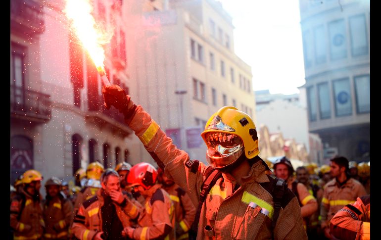 Un bombero enciende una bengala durante una protesta en Barcelona, España, para demandar más trabajadores y recursos. AFP/J. Lago