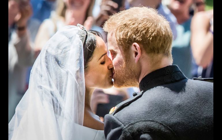 El príncipe Enrique de Inglaterra besa a su esposa Meghan Markle, tras su boda en el castillo de Windsor el 19 de mayo. AFP/D. Lawson