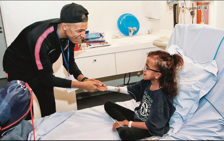Kylian Mbappé conforta a una niña de un hospital parisino, en una actividad del PSG. El astro galo apenas cumplió 20 años y acumula marcas al por mayor. EFE