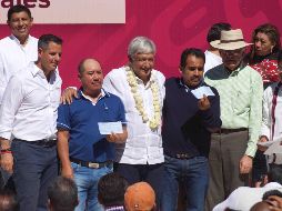 El presidente Andrés Manuel López Obrador (centro) durante la firma del acuerdo del Programa de Pavimentación de Caminos a Cabeceras Municipales en San Juan Evangelista Analco. SUN