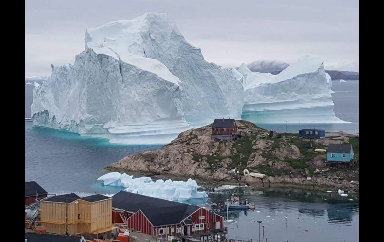 Un iceberg situado al lado de la aldea de Innaarsuit, en el municipio de Avannaata, Groenlandia, el 12 de julio. Habitantes de Avannaata fueron advertido de abandonar la aldea debido a la aparición de un iceberg de grandes proporciones, ya que si se fracturara, podría causar un tsunami. EFE/K. Petersen