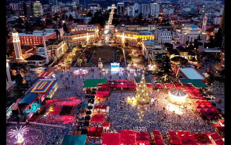 Vista de la plaza principal de Tirana, Albania, iluminada con decoraciones festivas y con un mercado navideño. AFP/G. Shkullaku