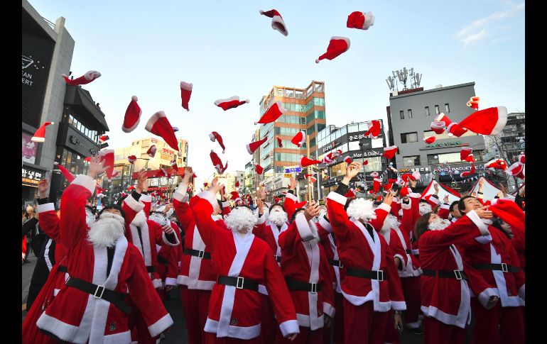Voluntarios en disfraces de Santa Claus asisten a una ceremonia para entregar regalos a familias pobres en Seúl, Corea del Sur. AFP/J. Yeon-je