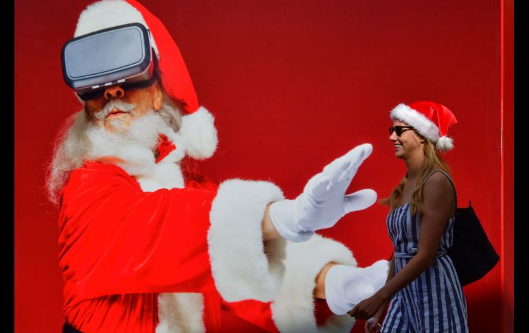 Una mujer pasa junto a un póster de Santa Claus en Dubai, Emiratos Árabes Unidos. AFP/G. Cacace