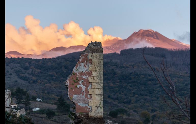 Los restos de una estructura colapsada se ven con columnas de humo al fondo, procedentes de la erupción del volcán Etna, en la ciudad italiana de Fleri. AP/S. Allegra