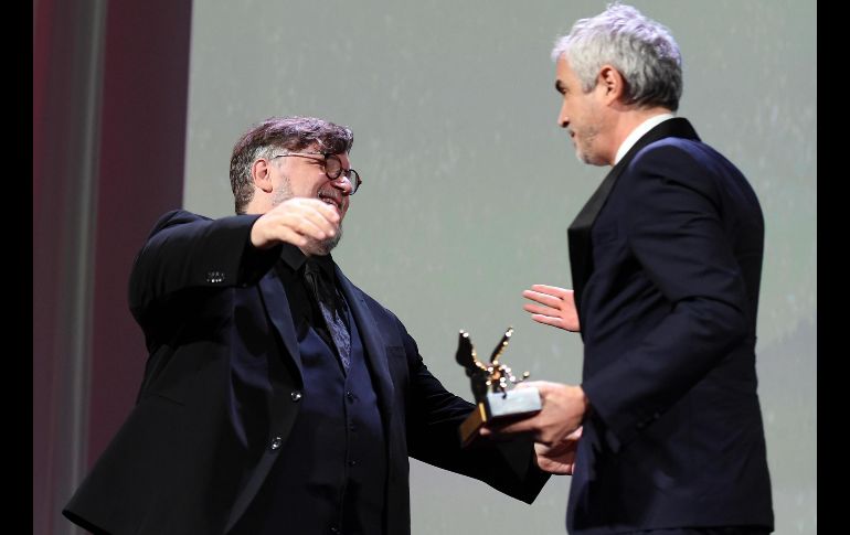 El director de cine mexicano Guillermo del Toro (i) entrega a su compatriota Alfonso Cuarón el premio Léon de Oro del Festival de Cine de Venecia por su cinta 