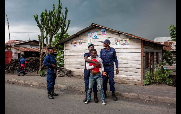 Policías arrestan a un hombre en Majengo, República Democrática del Congo. El país celebra el domingo elecciones, aplazadas en repetidas ocasiones, y los días previos han estado marcados por protestas y enfrentamientos violentos. AFP/P. Meinhardt