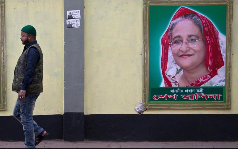 Una mujer camina cerca de una propaganda a favor de Sheikh Hasina, quien se perfila para su cuarto mandato. AP/A. Nath