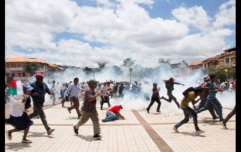 Simpatizantes del candidato presidencial Marc Ravalomanana huyen de los gases lacrimógenos lanzados durante una protesta en Antananarivo, Madagascar, en reacción a los resultadados de las elecciones del 19 de diciembre. Según los resultados oficiales, Ravalomanana obtuvo el 44% de los votos, frente a Andry Rajoelina, que ganó con el 55%. AFP/Mamyrael