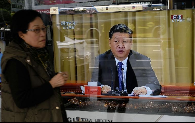 Ciudadana de Taipéi mira a través de un escaparate la transmisión del discurso de Xi Jinping por el 40 aniversario del Mensaje a los Compatriotas en Taiwán. AFP/S. Yeh