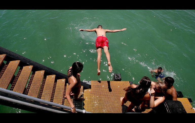 Un adolescente salta desde el muelle de Henley Beach en Adelaide, Australia. Las temperaturas se dispararon en el sur de Australia a cerca de 50 grados centígrados en algunas ciudades regionales. EFE/K. Barnes