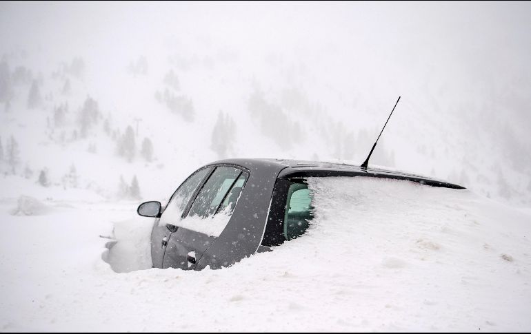 A lo largo de las carreteras, varios vehículos atrapados entre la nieve se alcanzaban a vislumbrar como parte del paisaje. EFE/C. Bruna