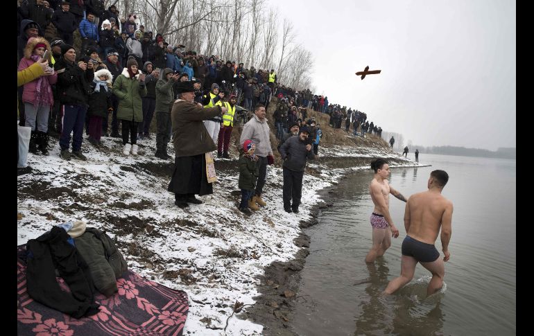 Jóvenes se preparan para buscar la cruz arrojada al río Danubio en la población rumana de Facaeni.