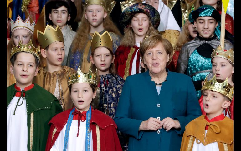 La canciller alemana Angela Merkel (frente a la derecha) canta en una recepción para integrantes de coros de villancicos en la cancillería en Berlín, Alemania. AP/M. Sohn