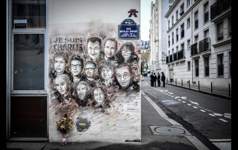 Policías se observan afuera de la ex oficina de Charlie Hebdo en París, Francia, previo a la ceremonia por el cuarto aniversario del ataque a las instalaciones de la revista satírica que dejaron 12 muertos. AFP/S. De Sakutin