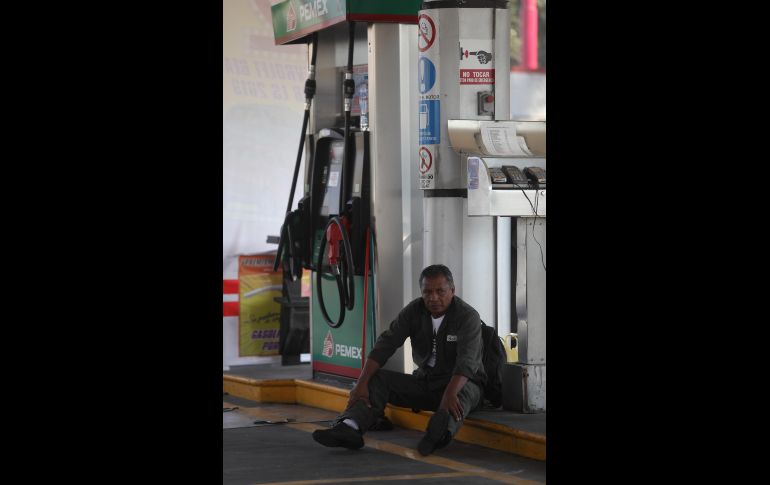 En el caso de Ciudad de México, los problemas están empezando a llegar a la zona sur de la capital. Un empleado de gasolinera se sienta junto a un surtidor sin servicio.