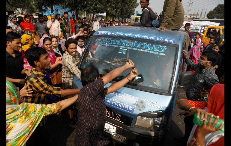 Trabajadores del sector textil vandalizan un auto durante una protesta en Savar, a las afueras de la capital de Bangladesh. Los inconformes exigen mejores salarios por cuarto día seguido en que han dejado de trabajar. AP