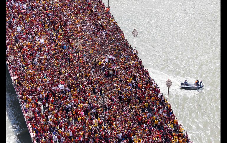 Fieles católicos cruzan un puente en procesión por la festividad del Nazareno Negro en Manila, Filipinas. Decenas de miles se unen a la romería, la mayoría descalzos. AP/B. Marquez