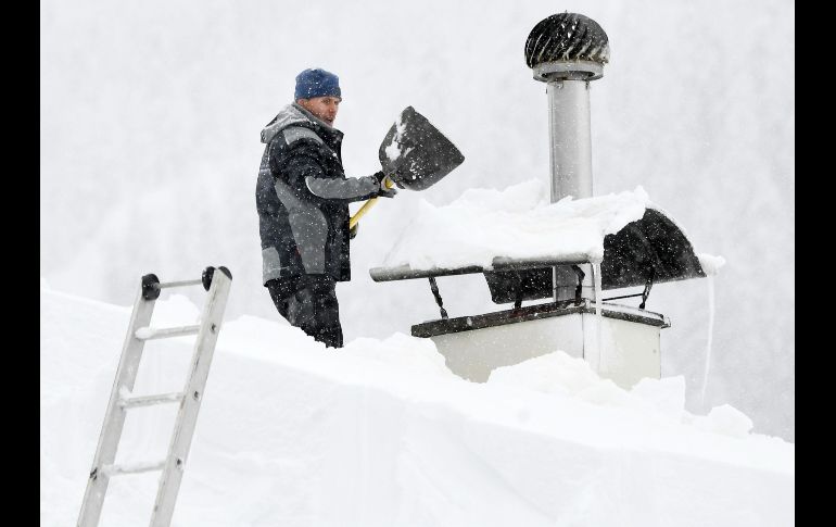Autoridades austriacas recomendaron a los dueños de casas que despejen la nieve de sus techos luego de que varios inmuebles se desplomaron. Un hombre retira nieve cerca de Obertauern, Austria.