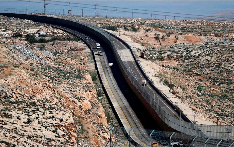Vehículos transitan por una nueva vía en Israel, dividida por un muro para separarla de los palestinos (I) y el lado para el uso exclusivo de israelíes y colonos en Jerusalén Este. AFP/T. Coex