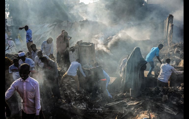 Habitantes intentan recuperar artículos de entre los escombros del mercado Bakara, luego de un incendio desatado anoche, en Mogadiscio, Somalia. AFP/M. Abdiwahab