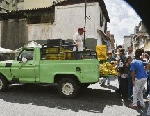 Un grupo de personas busca alimentos en los alrededores de un mercado de la capital venezolana. AFP