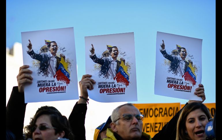 Manifestantes protestan en Madrid, España, contra el presidente de Venezuela, Nicolás Maduro. Sostienen imágenes de Juan Guaido, el presidente de la Asamblea Nacional de Venezuela y opositor al gobierno de Maduro. AFP/O. Del Pozo