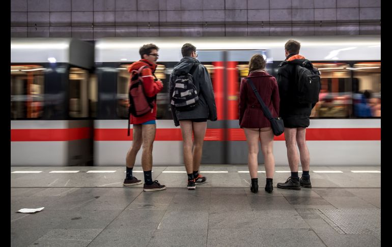 Jóvenes sin pantalones aguardan en una estación de metro en Praga, República Checa.
