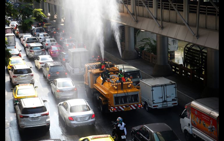 Personal de Vialidad rocía agua con la intención de reducir la fuerte contaminación en Bangkok, Tailandia. AP/S. Lalit