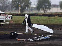 Un experto forense mueve un cuerpo encontrado en la zona de la tragedia. AFP / A. Estrella