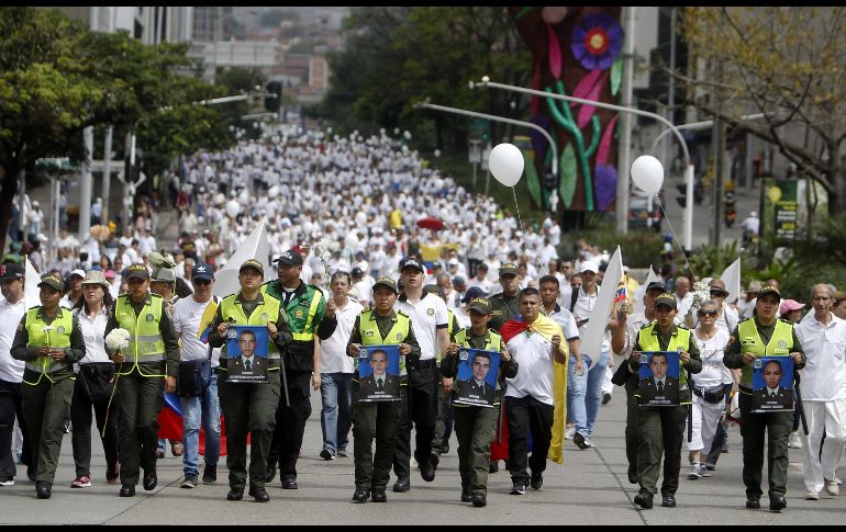 Policías y ciudadanos participan en una marcha en Medellín, Colombia. Miles de colombianos salieron a calles de todo el país para protestar contra el terrorismo que el jueves se cobró la vida de 20 cadetes y dejó 68 heridos por la detonación de una camioneta bomba en la Escuela de la Policía en Bogotá, ataque atribuido a la guerrilla del ELN. EFE/L. Noriega