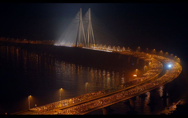 Corredores pasan por un puente junto al mar Arábigo durante su participación en el maratón de Bombay, en India. AP/R. Maqbool