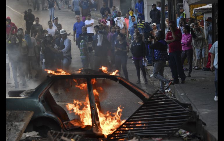 Ciudadanos protestan cerca de las instalaciones de la Guardia Nacional en el barrio Cotiza en Caracas, Venezuela. Militares atrincherados en el lugar llamaron en un video a desconocer al presidente Nicolás Maduro. AFP/Y. Cortez