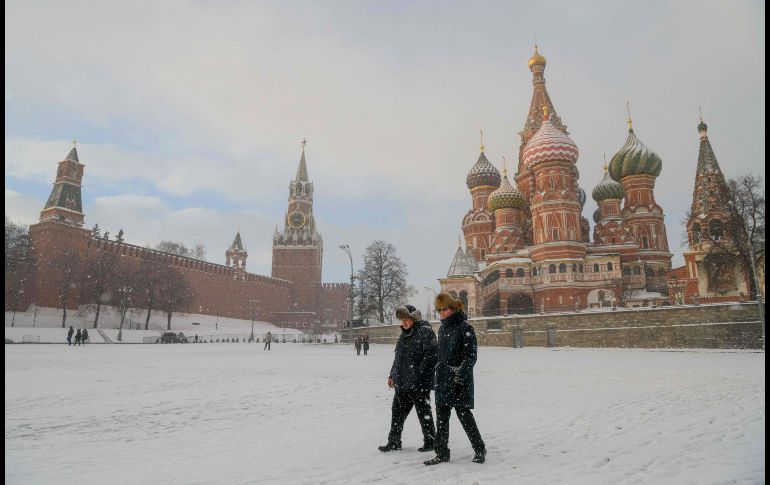 Personas caminan frente a la catedral de San Basilio y el Kremlin en Moscú, la capital rusa. AFP/M. Antonov