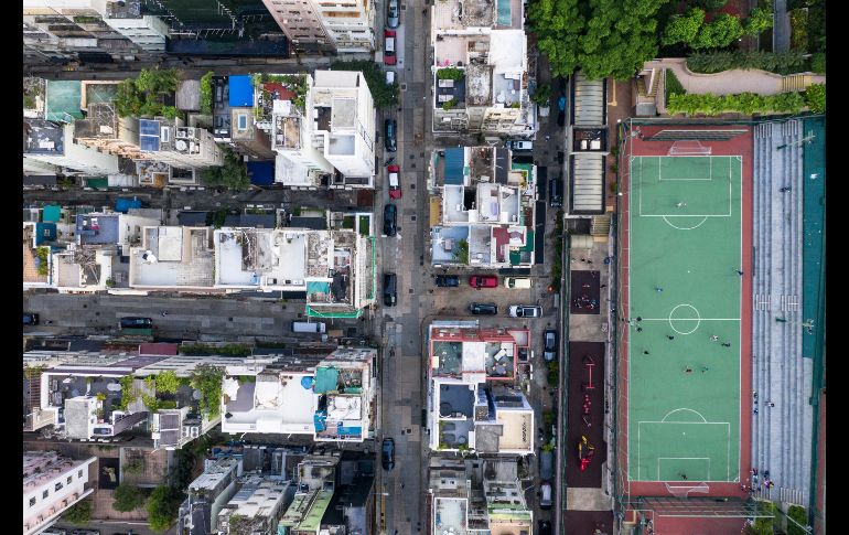 Desde el cielo también se puede distinguir una variedad de escenarios. Personas juegan futbol en un parque junto a viviendas. AFP/D. de la Rey