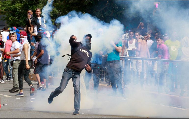 Miembros de la Policía Nacional Bolivariana lanzan gases lacrimógenos y perdigones contra manifestantes. EFE/C. Hernández