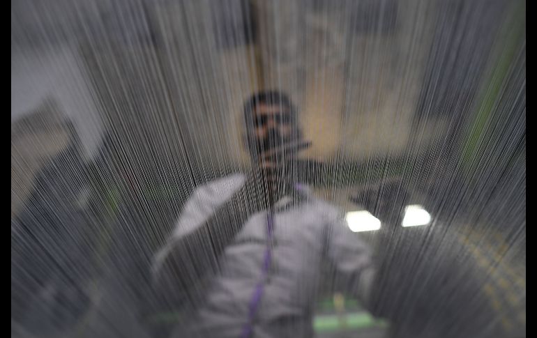 Un trabajador del sector textil revisa la calidad del hilo en Karachi, Pakistán. AFP/A. Hassan