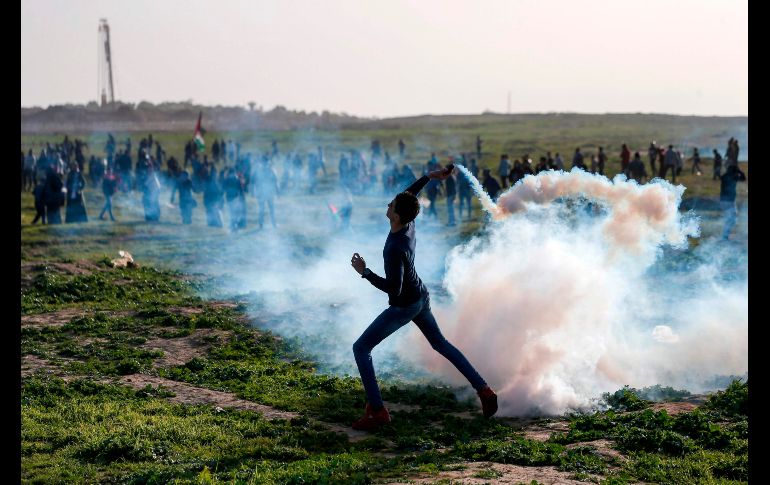 Un palestino devuelve una lata de gas lacrimógeno a fuerzas israelíes, durante enfrentamientos en la frontera de la Ciudad de Gaza con Israel. AFP/M. Hams
