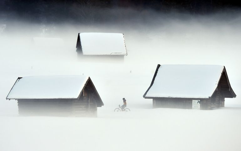 Un ciclista transita por Garmisch-Partenkirchen, en el sur de Alemania, durante una mañana fría y con neblina. AFP/C. Stache