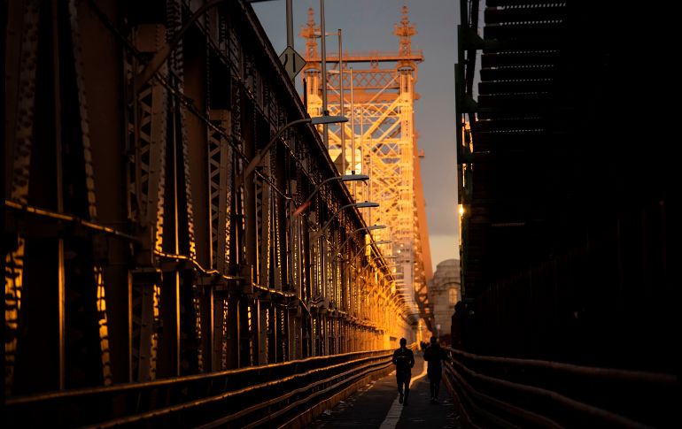 Dos hombres corren sobre el puente Queensboro hacia Manhattan en la ciudad de Nueva York. AFP/J. Eisele