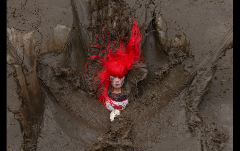 Una participante cae en el lodo durante la competencia de resistencia 