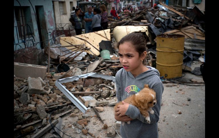 Una niña con su mascota observa la destrucción ocasionada por un tornado en La Habana, Cuba. AP/R. Espinosa